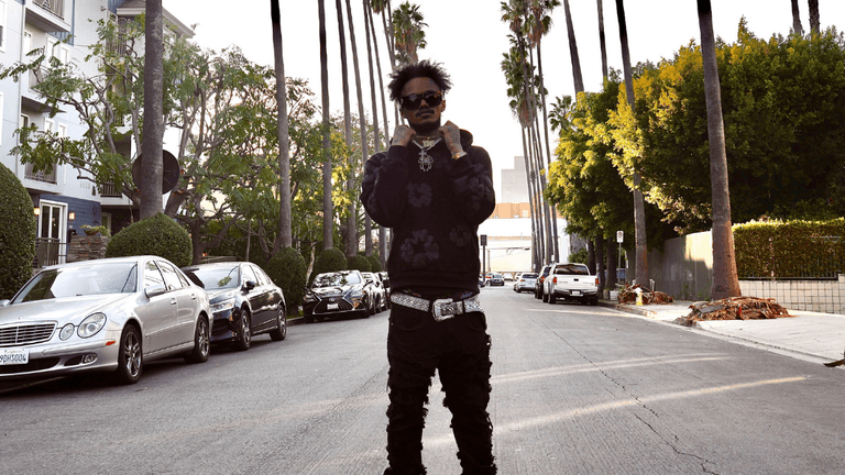 "Hip-hop artist KingfromHeaven standing on a Los Angeles street, embodying the energy and style of the city's music scene."