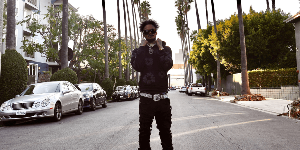 "Hip-hop artist KingfromHeaven standing on a Los Angeles street, embodying the energy and style of the city's music scene."