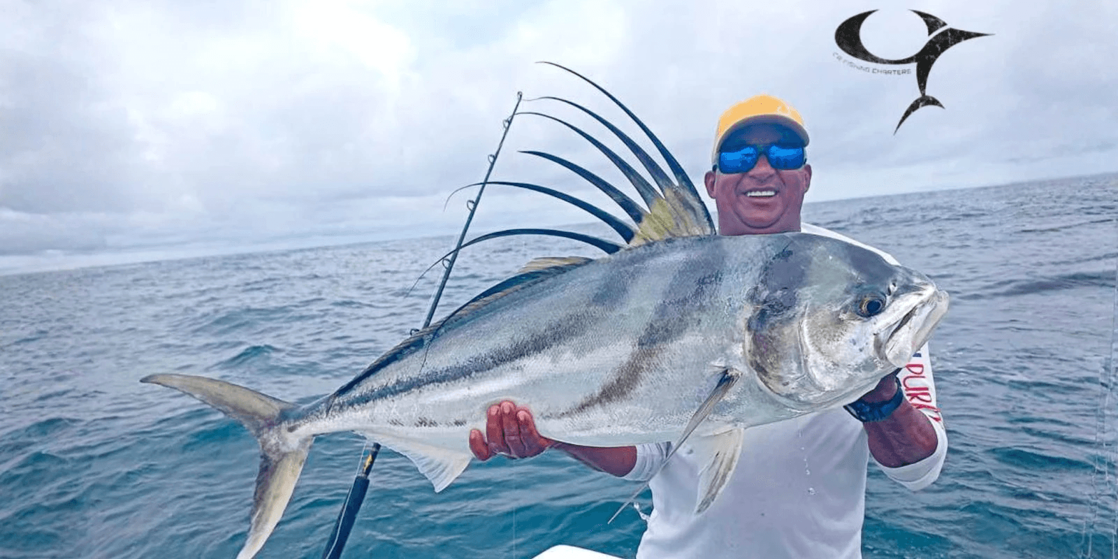 1. **A proud angler holds a massive roosterfish caught off Costa Rica's Pacific coast.**