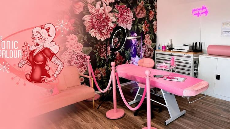 Interior of The Iconic Parlour featuring treatment bed, floral mural, and welcoming beauty studio environment.