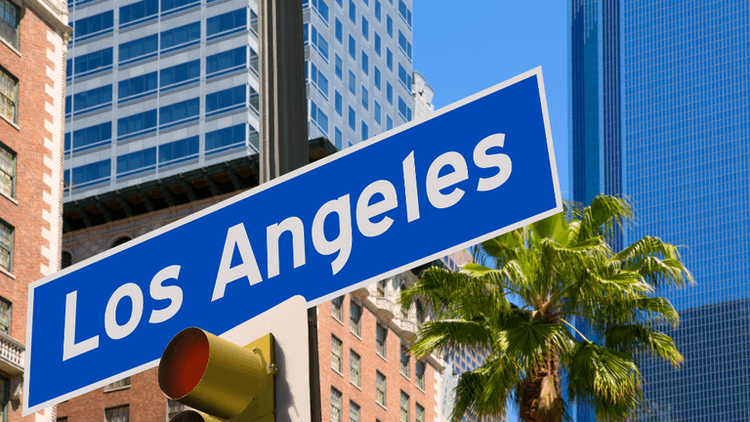 Los Angeles street sign with palm tree and skyscrapers in the background