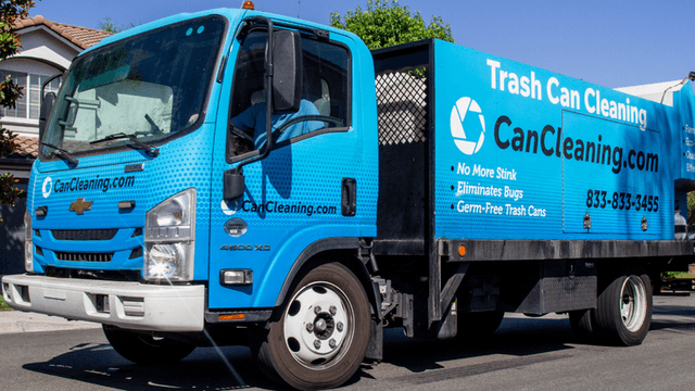 A blue trash cleaning truck parked on a residential street