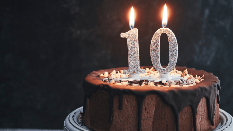 Chocolate cake with two candles glowing and the number 10 on top