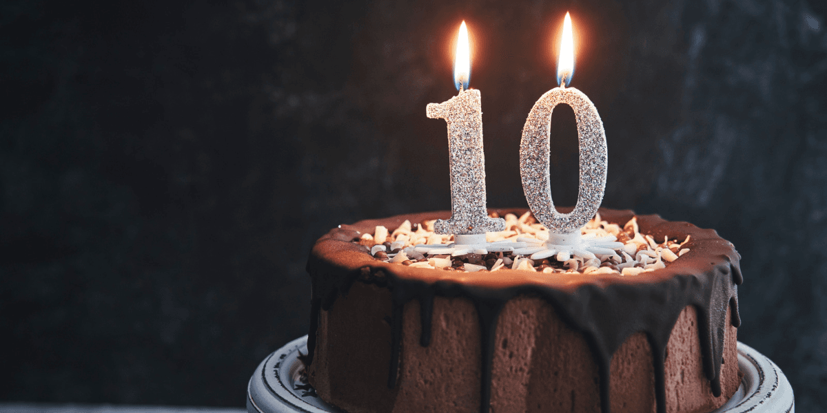 Chocolate cake with two candles glowing and the number 10 on top