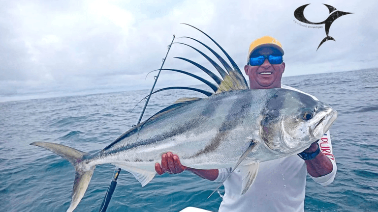 1. **A proud angler holds a massive roosterfish caught off Costa Rica's Pacific coast.**