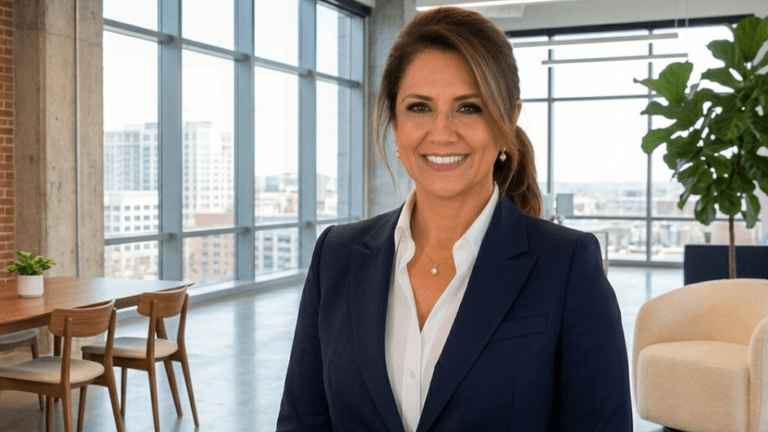 Professional woman smiling in a modern office with city skyline background.