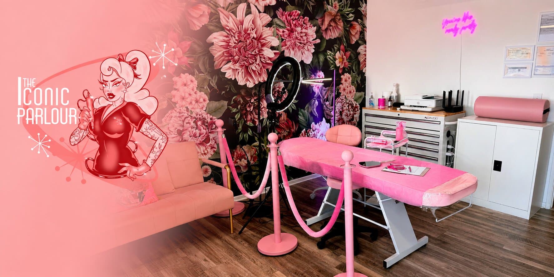 Interior of The Iconic Parlour featuring treatment bed, floral mural, and welcoming beauty studio environment.