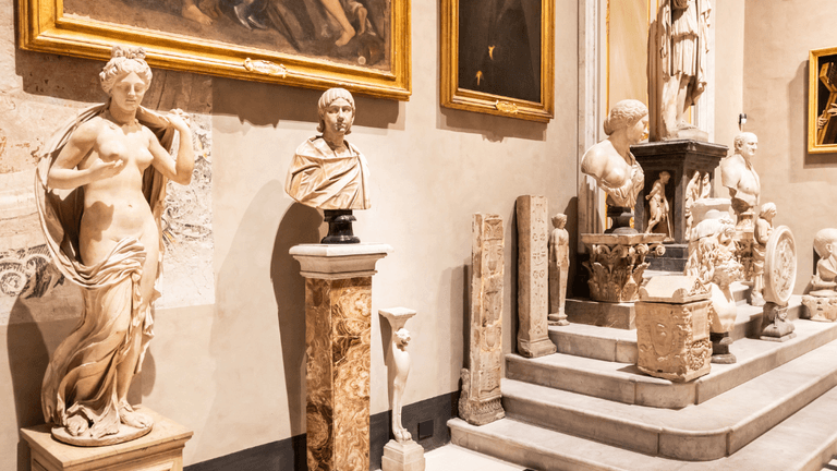 Interior of a museum showcasing classical sculptures and paintings along the walls